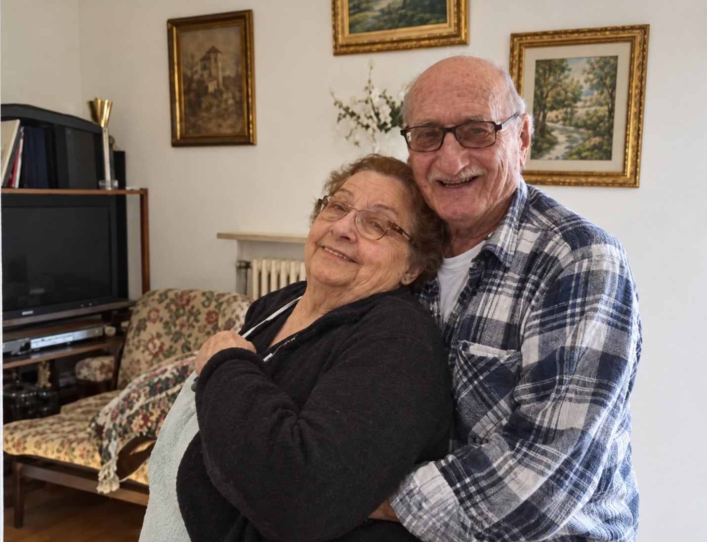 Erminio stringe Rina in un abbraccio nel salotto di casa